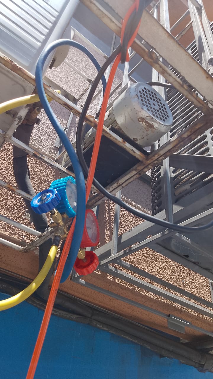 Juego de manómetros conectado durante la carga de gas refrigerante