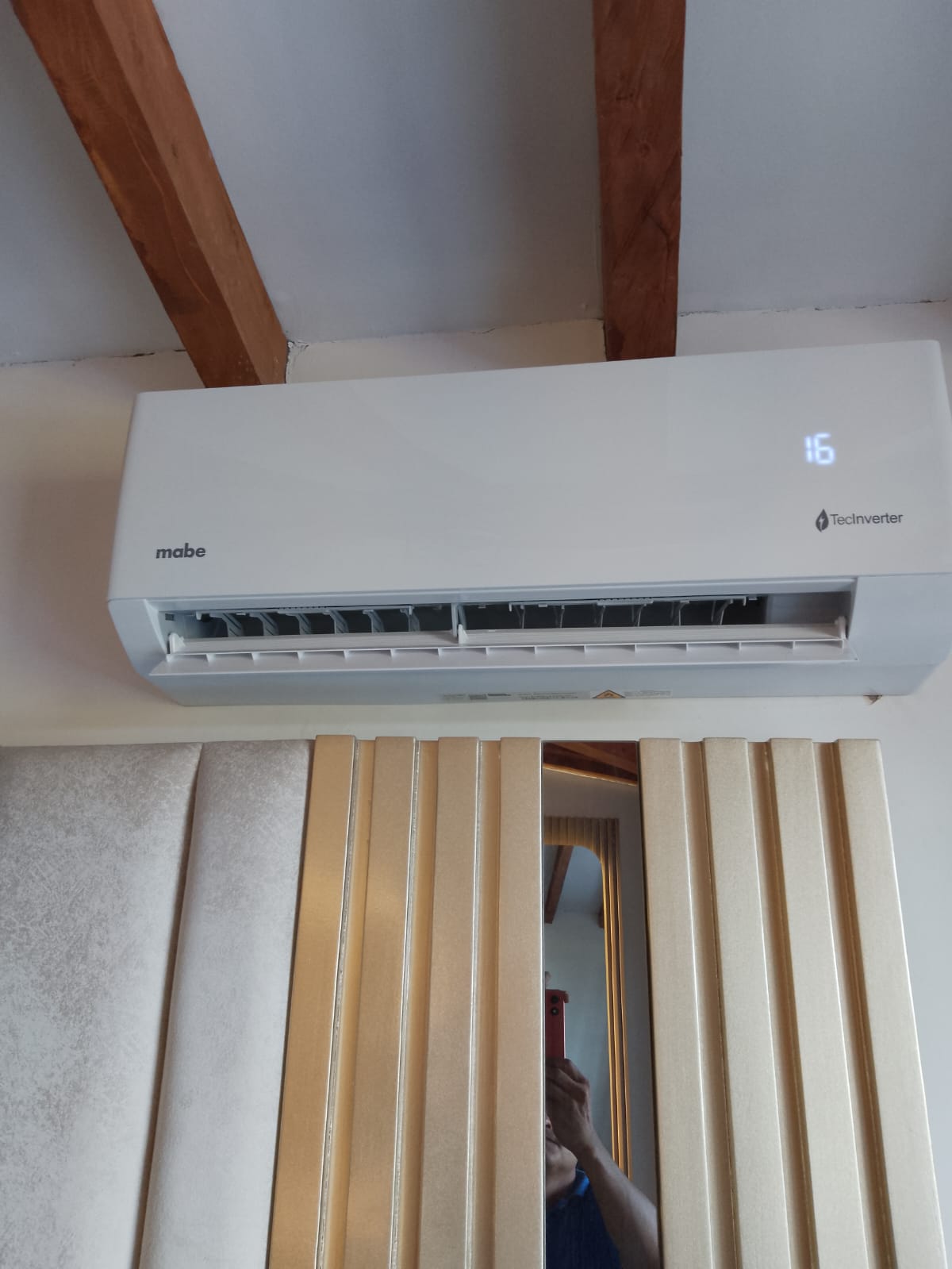 Mini split instalado en vivienda, con el display marcando 16 grados